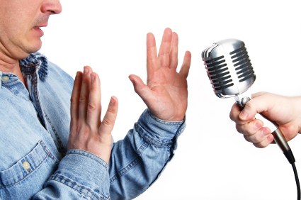 Original illustration of a man raising his hands as a microphone is offered to him.